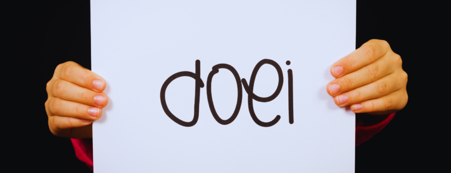 a young boyholding a sign that says the Dutch word "doei"