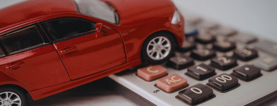Red toy car on calculator illustrating auto financing and costs