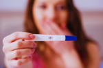 A woman holds up a positive pregnancy test
