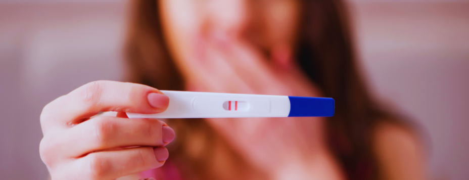 A woman holds up a positive pregnancy test