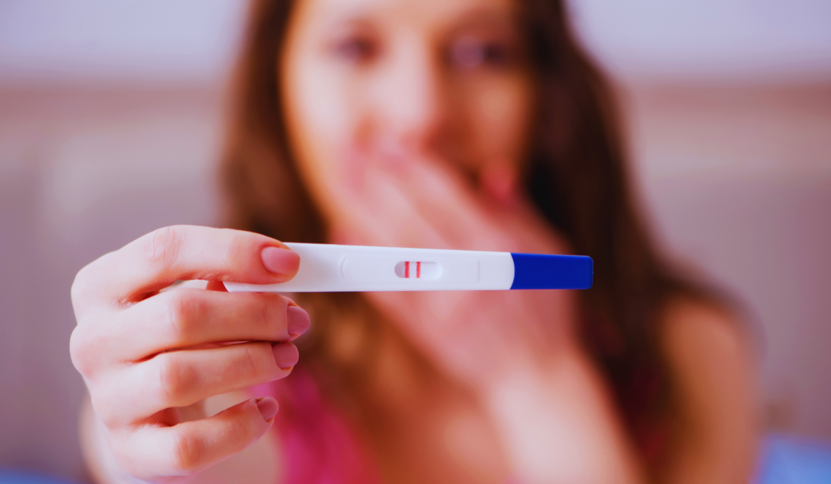 A woman holds up a positive pregnancy test