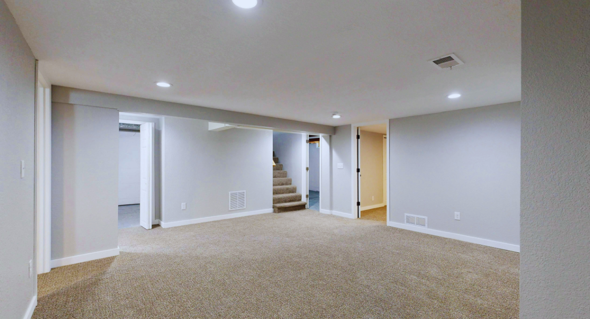 A spacioius modern basement with a neutral design