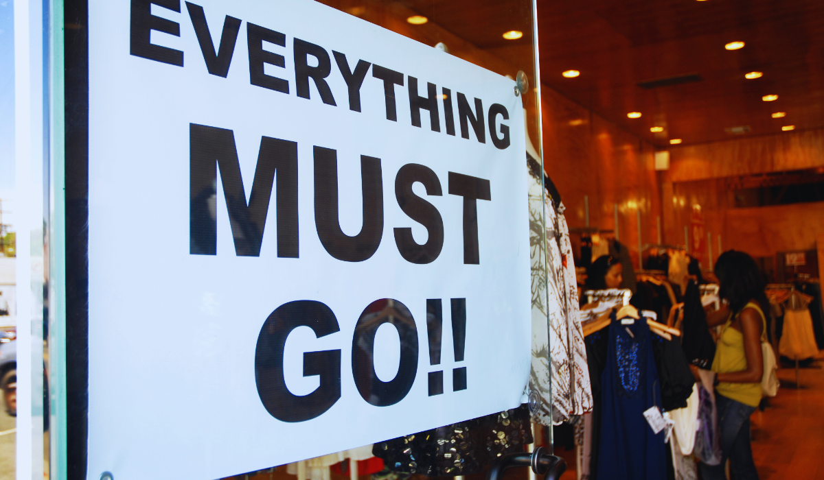 An "everything must go" sign hanging in a shop window