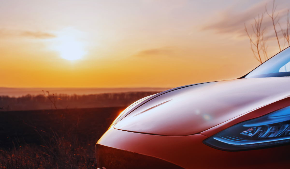 A red Tesla Model 3 at sunset in the Netherlands