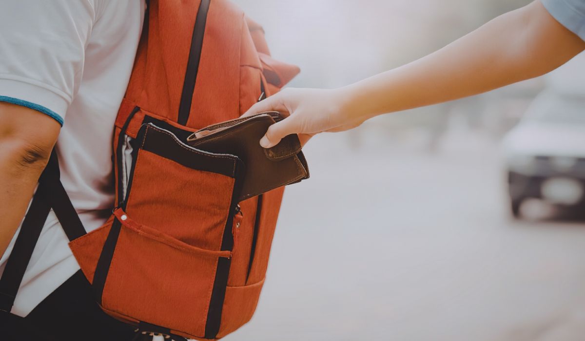 Person reqching into someone else's backpack to steal their wallet
