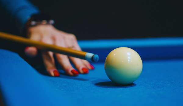 Closeup of a woman striking a pool ball