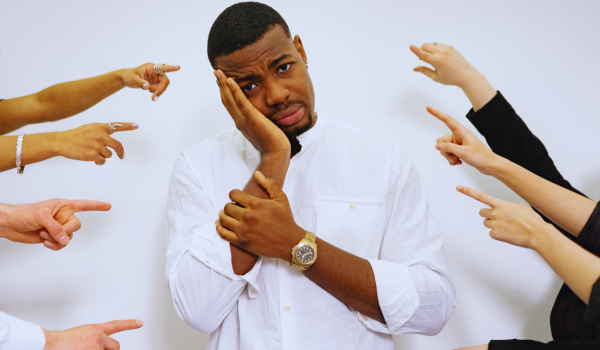 Many fingers pointing at a man