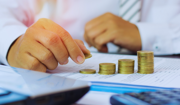 business man stacking change to represent his capital growth