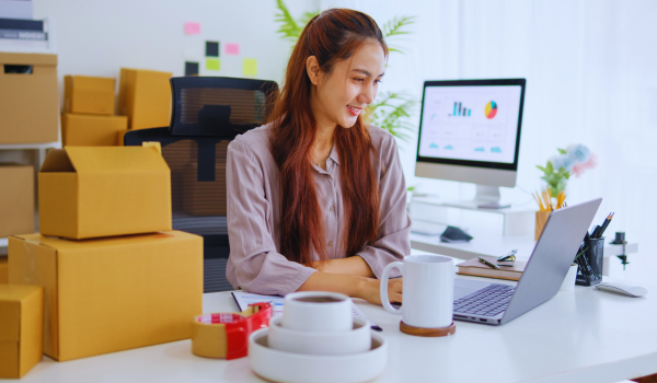 Female online sellter working on her laptop to process e-commerce