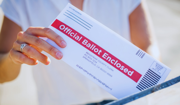 woman mailing her absentee ballott while voting in the 2026 US midterm elections from the netherlands