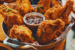 a basket of fried chicken with dip