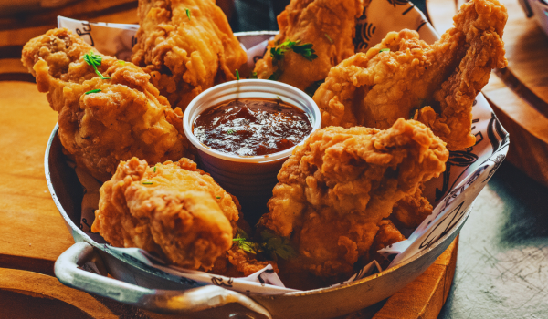 a basket of fried chicken with dip